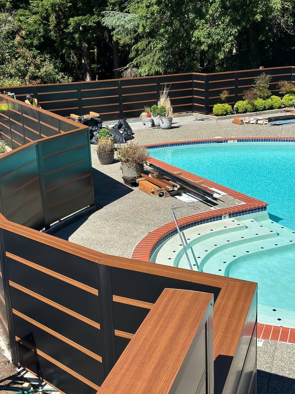 Custom metal privacy fence around a pool deck