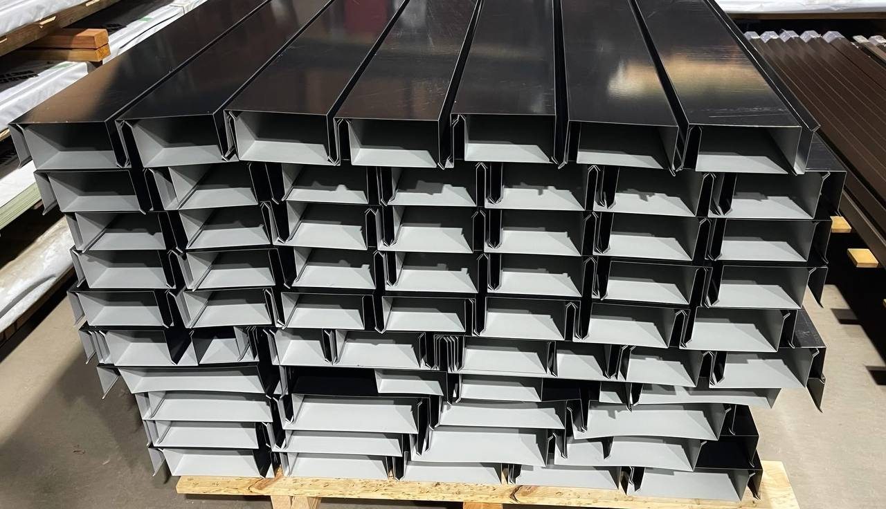 Custom-bent metal coping and box gutters stacked in the Unimasters shop